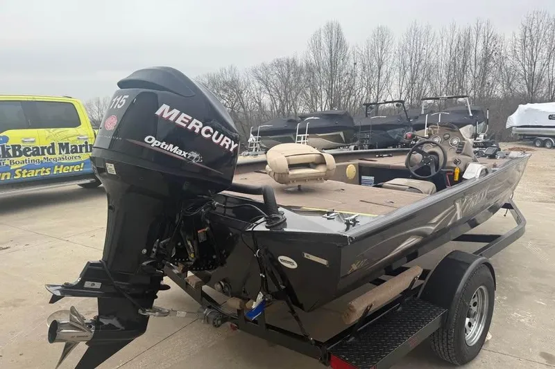Slide: The Image of 2004 Express x17 boat with Mercury OptiMax engine on trailer, parked outdoors. - 5