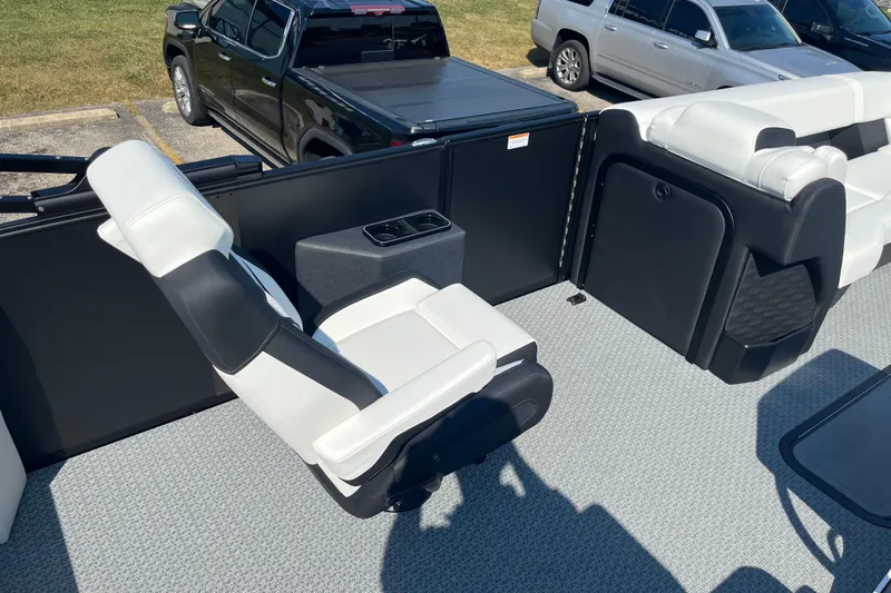 Slide: The Image of Interior of 2026 Evotti 725CS boat with white and black seating, parked vehicles visible. - 11