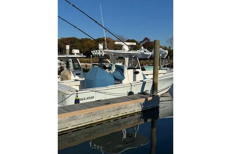 Slide: The Image of 2023 Regulator 31 boat docked at marina under clear blue sky. - 12