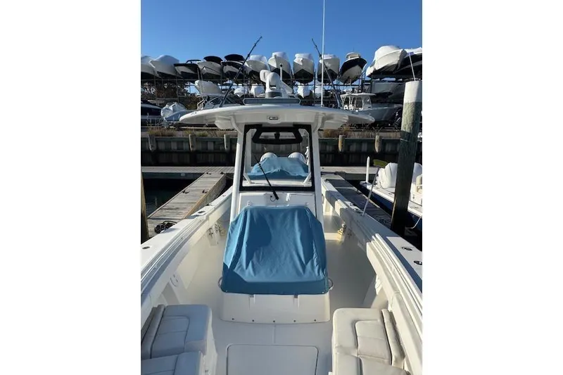 Slide: The Image of 2023 Regulator 31 boat docked, featuring a blue cover and spacious seating. - 18