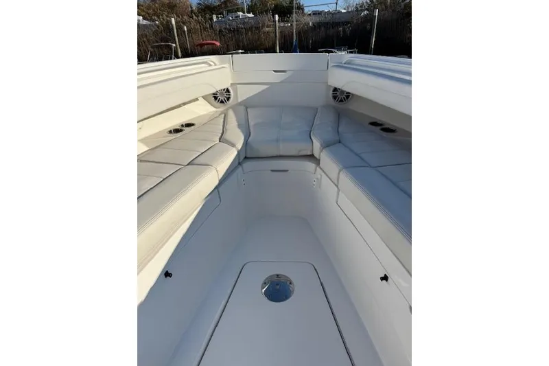 Slide: The Image of 2023 Regulator 31 boat interior with white cushioned seating and cup holders. - 19
