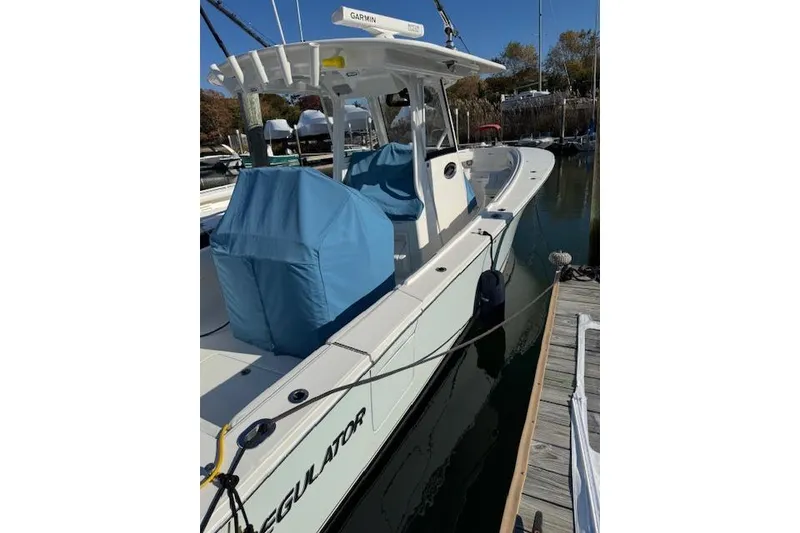 Slide: The Image of 2023 Regulator 31 boat docked, featuring covered seating and Garmin equipment. - 21