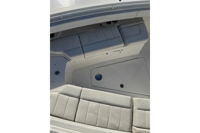 Slide: The Image of 2023 Regulator 31 boat interior with cushioned seating and storage compartments. - 29