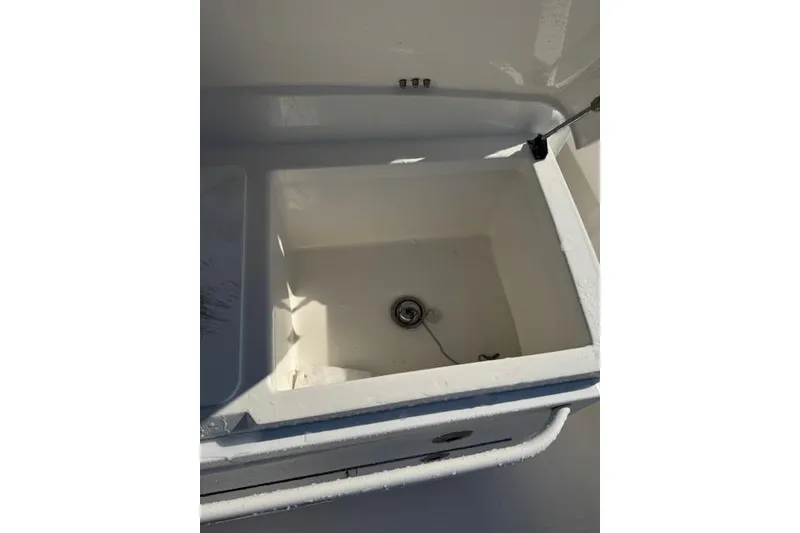 Slide: The Image of Livewell compartment on a 2023 Regulator 31 boat, featuring a clean, white interior. - 39