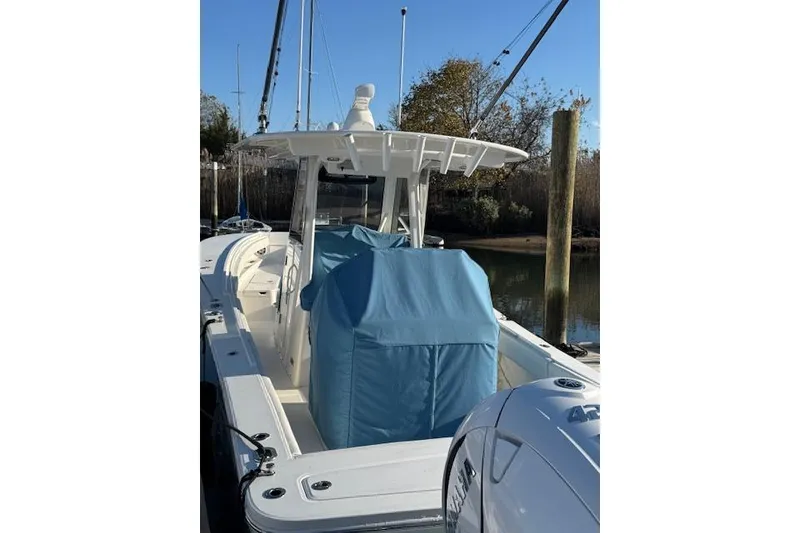 Slide: The Image of 2023 Regulator 31 boat with blue covers, docked in a marina. - 5