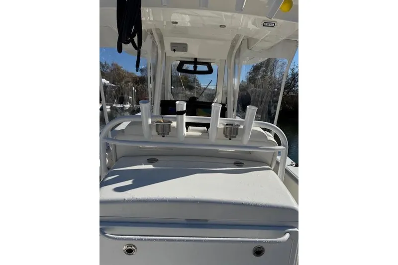 Slide: The Image of 2023 Regulator 31 boat interior with rod holders and console, under clear blue sky. - 55