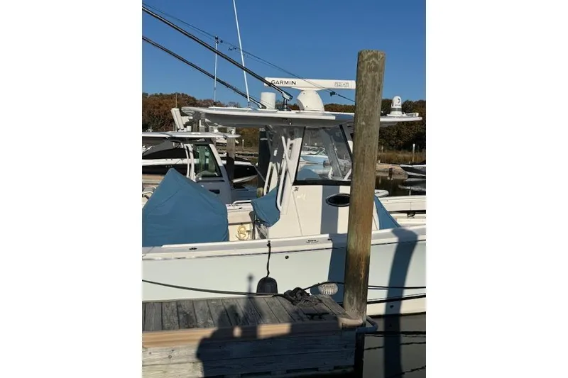 Slide: The Image of 2023 Regulator 31 boat docked, featuring Garmin equipment and covered seating. - 8