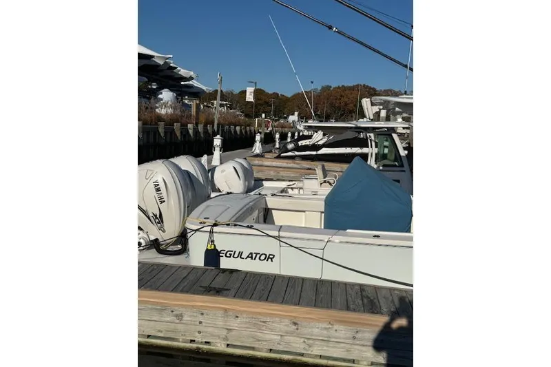 Slide: The Image of 2023 Regulator 31 boat docked with Yamaha engines, sunny day. - 9