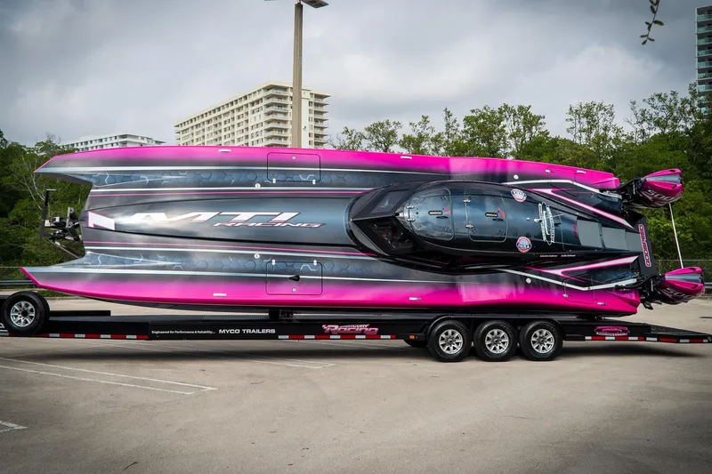 Slide: The Image of 2023 MTI 390XR powerboat with vibrant pink and black design on a trailer. - 14