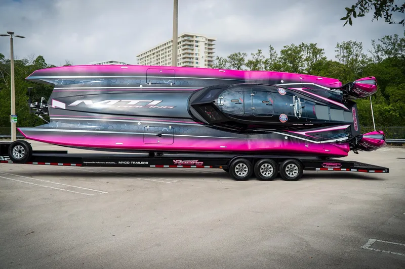 Slide: The Image of 2023 MTI 390XR powerboat with vibrant pink and black design on a trailer. - 15