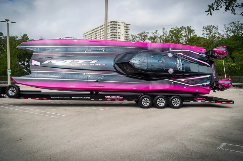 Slide: The Image of 2023 MTI 390XR powerboat on trailer, vibrant pink and black design, parked outdoors. - 16