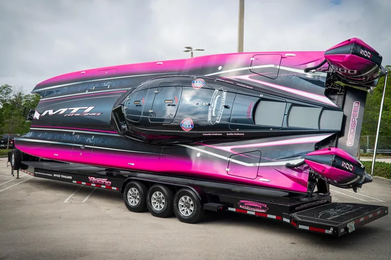 Slide: The Image of 2023 MTI 390XR powerboat on trailer, vibrant pink and black design, parked outdoors. - 17