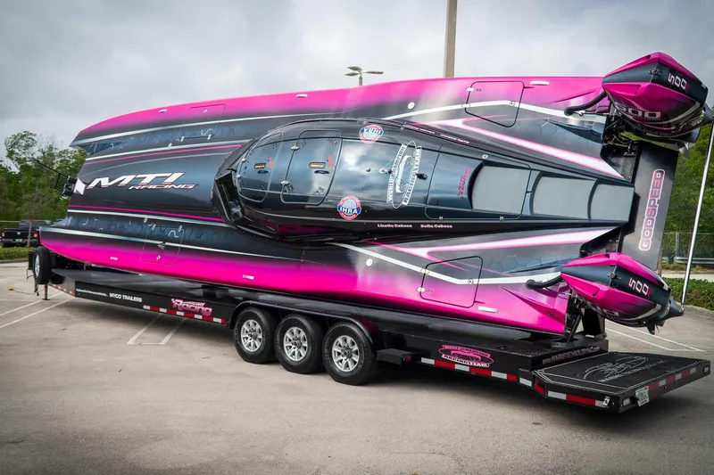 Slide: The Image of 2023 MTI 390XR powerboat on trailer, vibrant pink and black design, parked outdoors. - 18