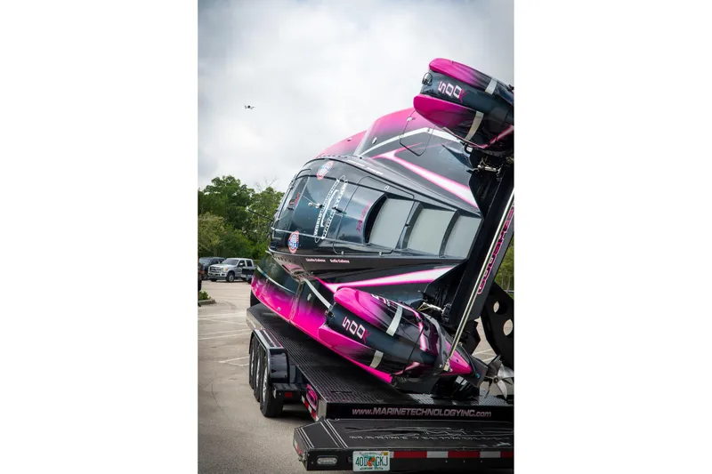 Slide: The Image of 2023 MTI 390XR powerboat with vibrant pink and black design on a trailer. - 19