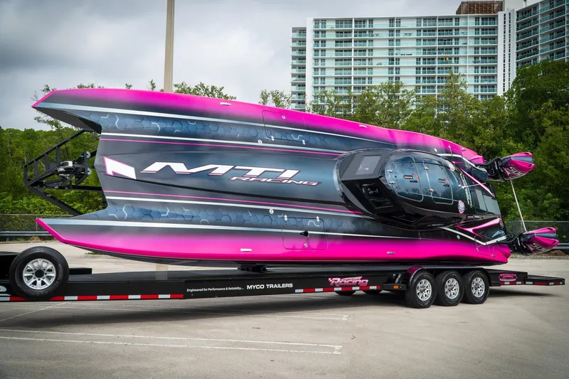 Slide: The Image of 2023 MTI 390XR powerboat on trailer, vibrant pink and black design, parked outdoors. - 22