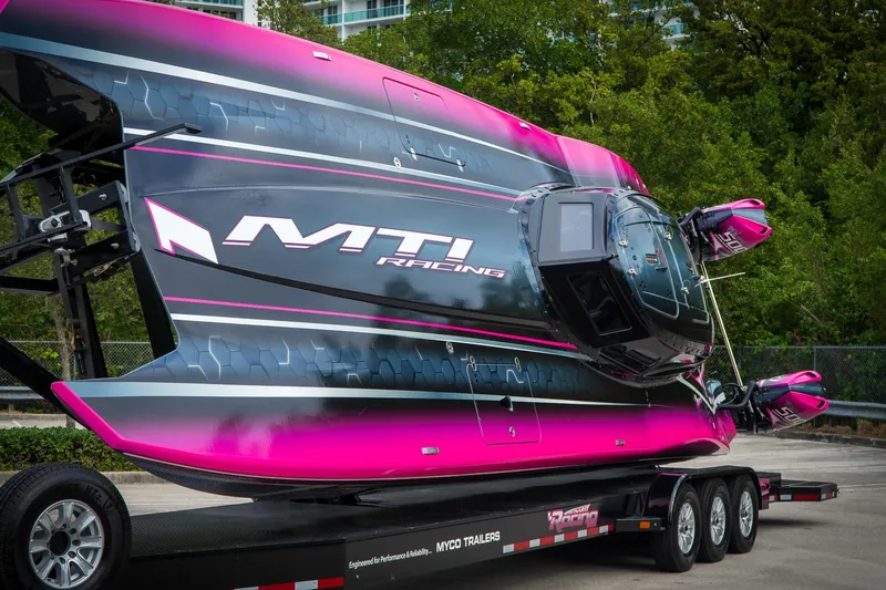 Slide: The Image of 2023 MTI 390XR racing boat on trailer, vibrant pink and black design. - 24
