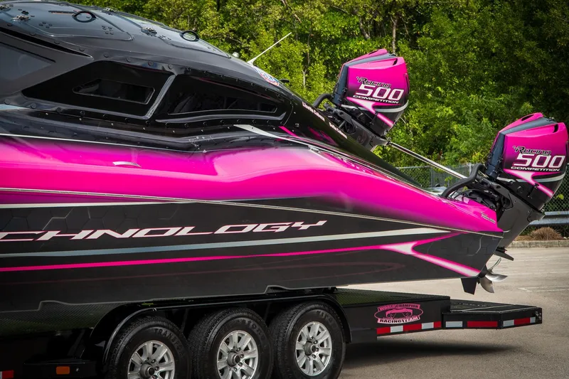 Slide: The Image of 2023 MTI 390XR powerboat with vibrant pink and black design on a trailer. - 27