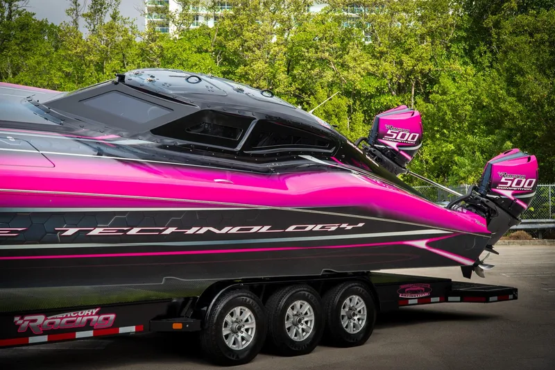 Slide: The Image of 2023 MTI 390XR powerboat with vibrant pink and black design on a trailer. - 28
