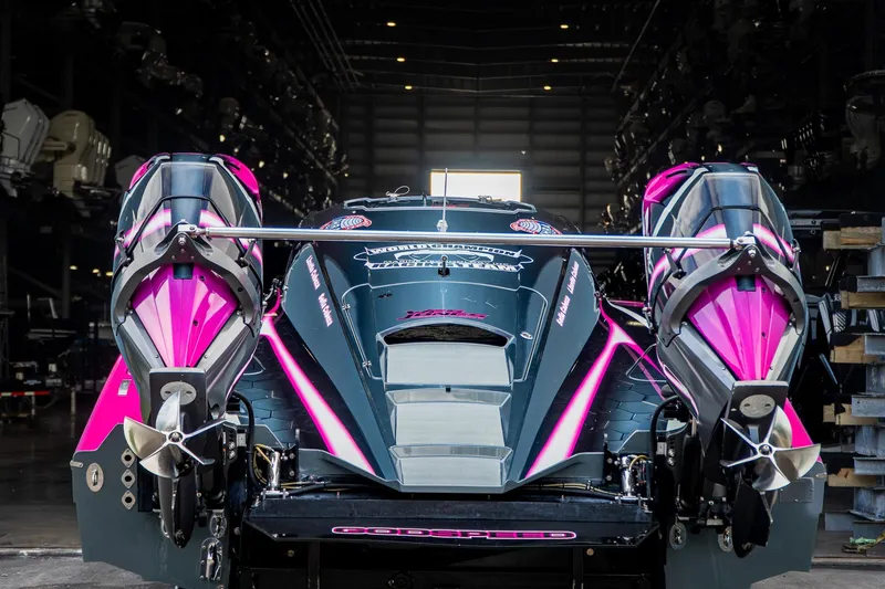 Slide: The Image of 2023 MTI 390XR powerboat with vibrant pink accents in a dimly lit warehouse. - 40