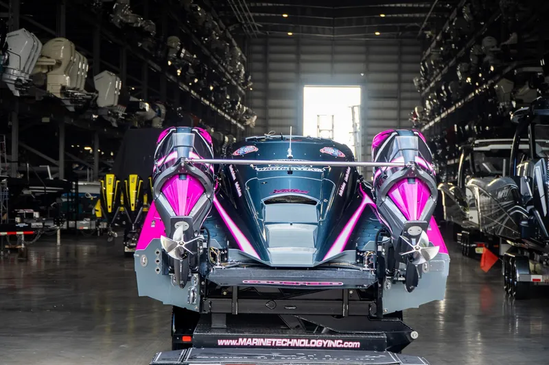 Slide: The Image of 2023 MTI 390XR speedboat with vibrant pink accents in a storage facility. - 41