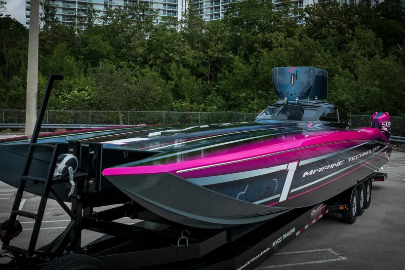 Slide: The Image of 2023 MTI 390XR powerboat with vibrant pink and black design on a trailer. - 43