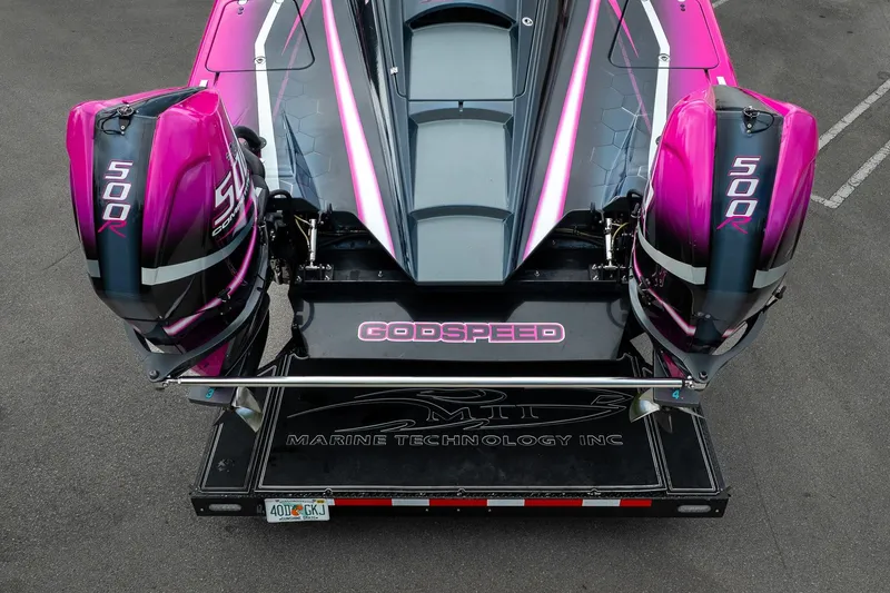 Slide: The Image of 2023 MTI 390XR boat with dual 500R engines, vibrant pink and black design. - 47