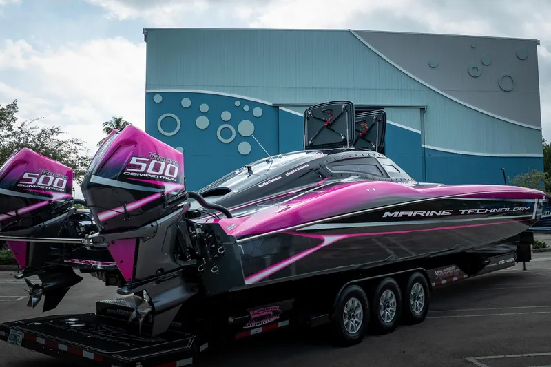 Slide: The Image of 2023 MTI 390XR powerboat with vibrant pink accents and twin 500 competition engines. - 54
