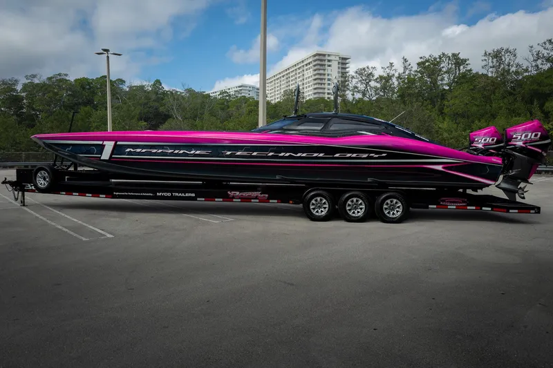 Slide: The Image of 2023 MTI 390XR powerboat with vibrant pink and black design on a trailer. - 68