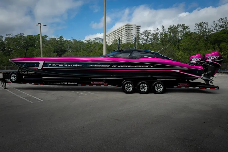 Slide: The Image of 2023 MTI 390XR powerboat with vibrant pink and black design on a trailer. - 69