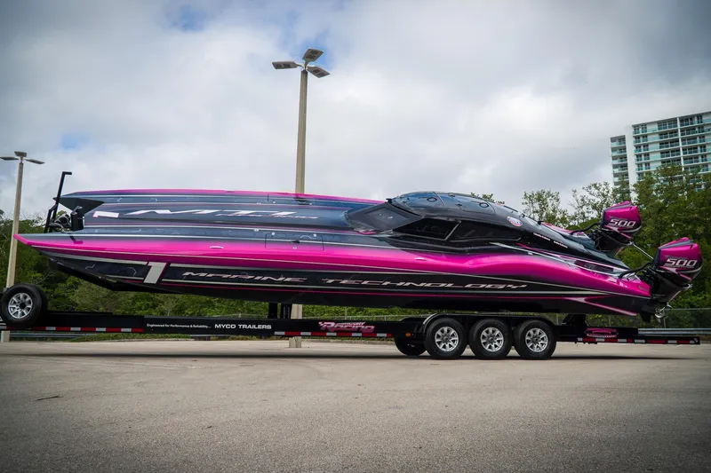 Slide: The Image of 2023 MTI 390XR powerboat with vibrant pink and black design on a trailer. - 7