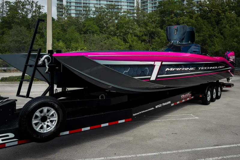 Slide: The Image of 2023 MTI 390XR powerboat on trailer, vibrant pink and black design, parked outdoors. - 71