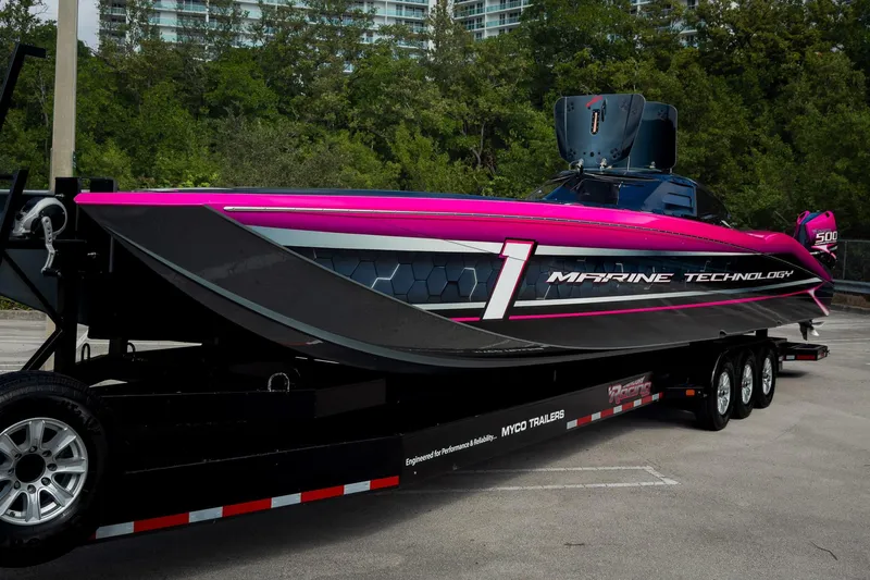 Slide: The Image of 2023 MTI 390XR powerboat on trailer, vibrant pink and black design, parked outdoors. - 72