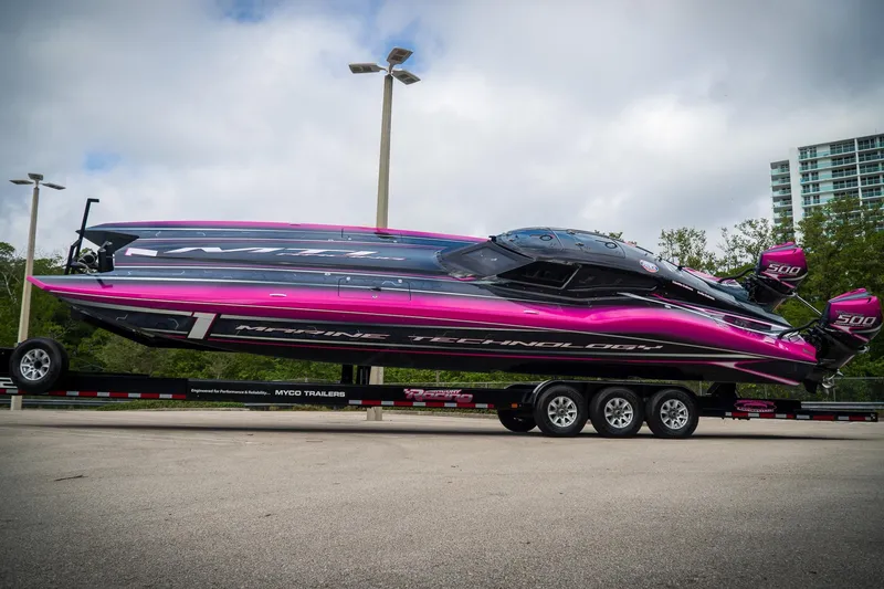 Slide: The Image of 2023 MTI 390XR powerboat with vibrant pink and black design on a trailer. - 8