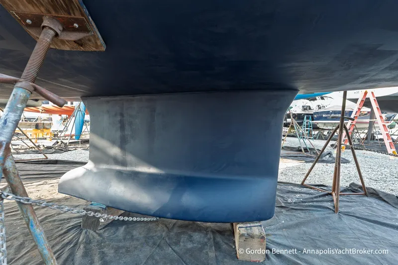 Slide: The Image of 2004 Jeanneau Sun Odyssey 43 DS sailboat keel in dry dock, supported by stands. - 59