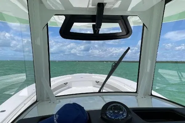 Slide: The Image of 2021 Regulator 34 boat interior view with compass, navigating clear waters. - 19
