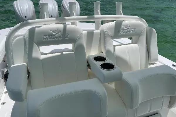 Slide: The Image of 2021 Regulator 34 boat with white cushioned seats and cup holders on the deck. - 22