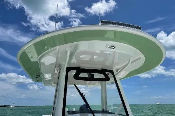 Slide: The Image of 2021 Regulator 34 boat with T-top against blue sky and ocean backdrop. - 23