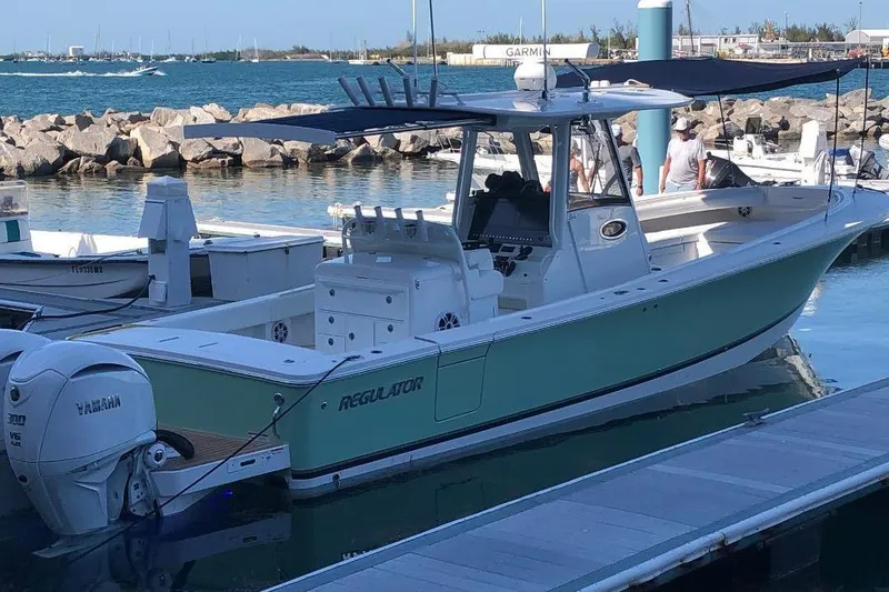Slide: The Image of 2021 Regulator 34 boat docked with Yamaha engines, in a marina setting. - 3
