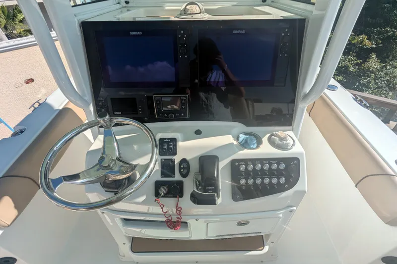 Slide: The Image of 2020 NauticStar 251 Hybrid boat console with steering wheel and navigation screens. - 3