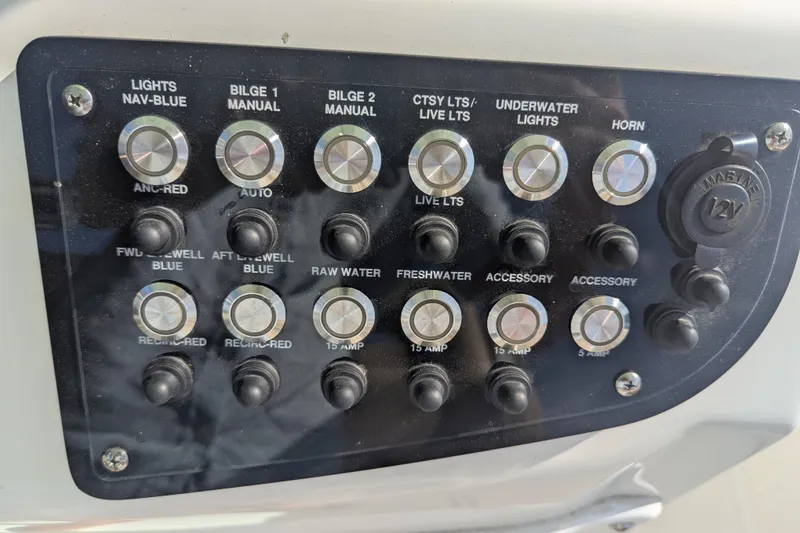 Slide: The Image of Control panel of a 2020 NauticStar 251 Hybrid boat with various switches and buttons. - 6