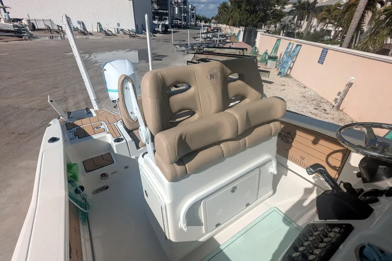 Slide: The Image of 2020 NauticStar 251 Hybrid boat interior with tan seating and control panel. - 8
