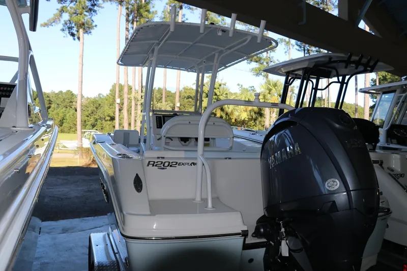 Slide: The Image of 2026 Robalo R202 Explorer boat with powerful outboard motor, docked among trees. - 4