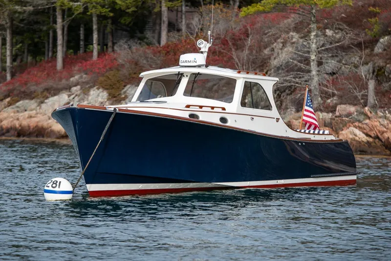 Slide: The Image of 2001 Hinckley Picnic Boat Classic on water, American flag, scenic background. - 1