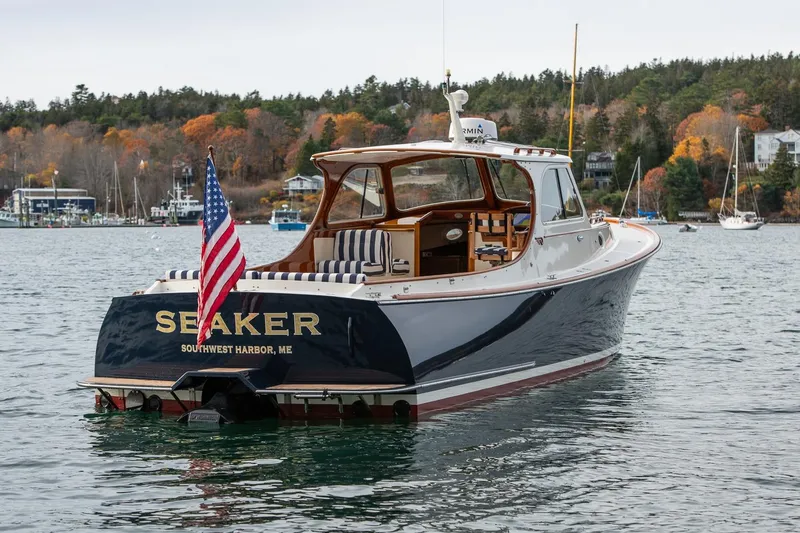 Slide: The Image of 2001 Hinckley Picnic Boat Classic on water, American flag, autumn trees in background. - 15