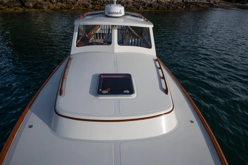 Slide: The Image of 2001 Hinckley Picnic Boat Classic on water, featuring sleek design and Garmin equipment. - 28