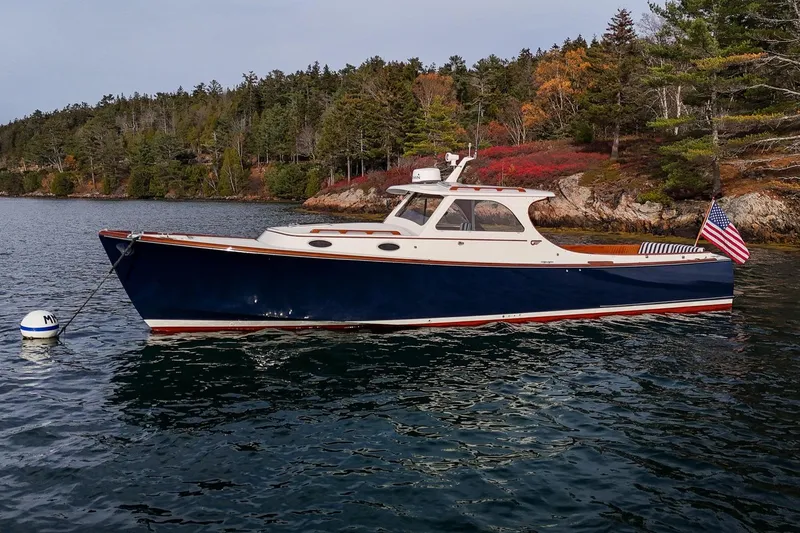 Slide: The Image of 2001 Hinckley Picnic Boat Classic moored on scenic water with forested shoreline. - 4