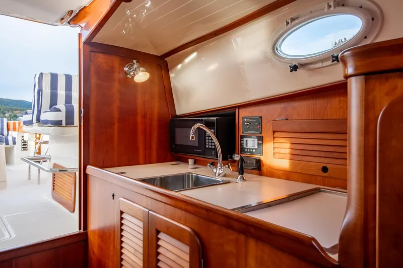 Slide: The Image of 2001 Hinckley Picnic Boat Classic interior with wooden cabinetry and modern amenities. - 40