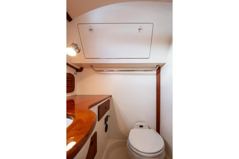 Slide: The Image of 2001 Hinckley Picnic Boat Classic bathroom with wooden accents and compact design. - 48