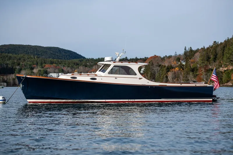 Slide: The Image of 2001 Hinckley Picnic Boat Classic on scenic lake with forested hills in background. - 53