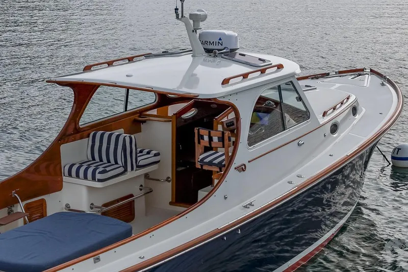 Slide: The Image of 2001 Hinckley Picnic Boat Classic on water, featuring elegant design and striped seating. - 20